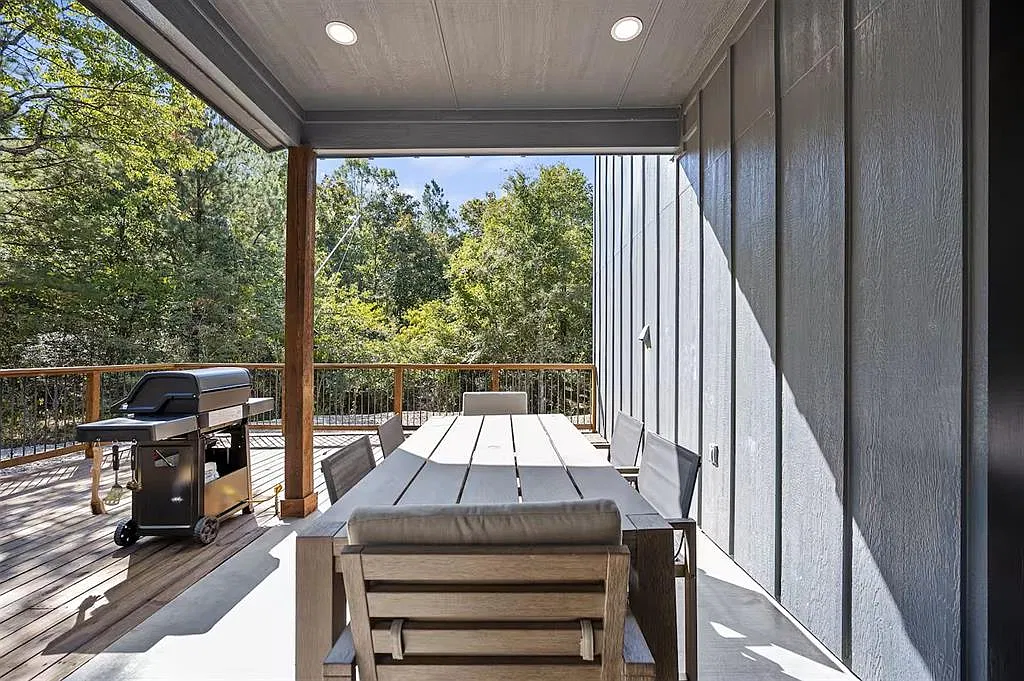 Covered deck with an outdoor dining table and grill
